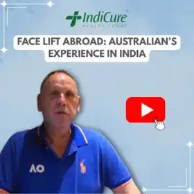A headshot of an Australian man named Andrew, wearing a blue polo shirt, promoting his experience with a facelift in India through IndiCure Health Tours.